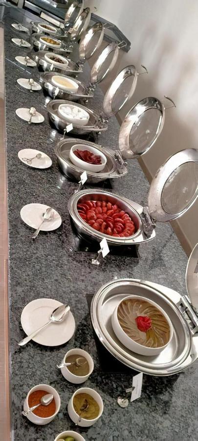 Tolip Resort El Galala Majestic Ain Sukhna Exterior foto The photo shows a buffet setup featuring multiple metal serving trays on a dark granite countertop. One tray contains circular slices of food, possibly sausages or a similar dish, while another bowl holds what appears to be red food items, though it'