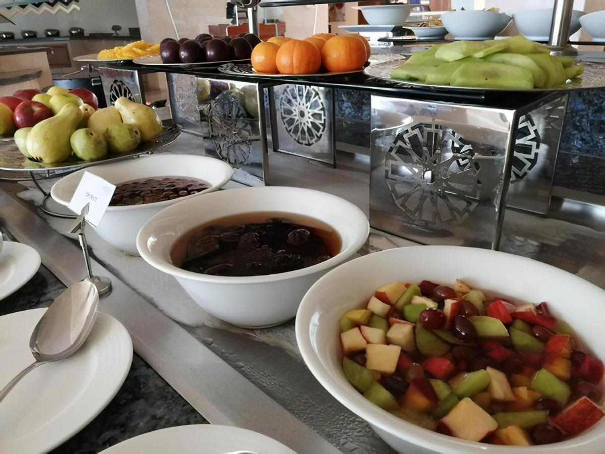 Tolip Resort El Galala Majestic Ain Sukhna Exterior foto The photo shows a buffet-style arrangement of various fruits and fruit dishes. In the foreground, there are several bowls containing different types of fruit. One bowl has a fruit salad made with diced apples, green apples, and possibly other fruits.